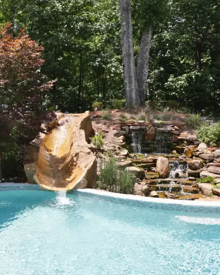 RutherfordMade pool with rock slide, waterfall, patio, planting beds, and landscape stonework
